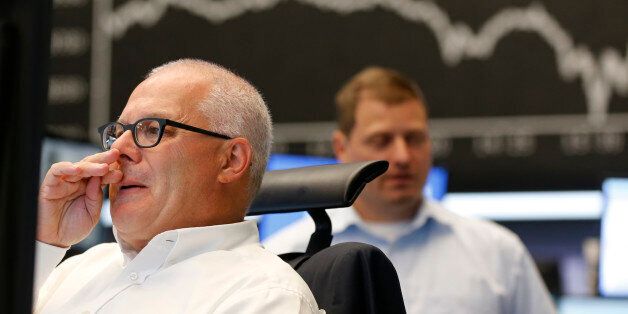 A trader wipes his nose when the curve of the German stock index DAX fell under 10,000 points at the stock market in Frankfurt, Germany, Monday, Aug. 24, 2015. (AP Photo/Michael Probst)