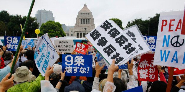 Protesters hold anti-war placards in front of the National Diet building during a rally in Tokyo, Sunday, Aug. 30, 2015. Thousands of Japanese protested outside the parliament a set of security bills designed to expand the role the country's military. The bills - a cornerstone of Prime Minister's Shinzo Abe's move to shore up Japan's defenses in the face of growing threats in the region - are expected to pass next month despite criticism they undermine Japanâs post-war pacifism. The placard