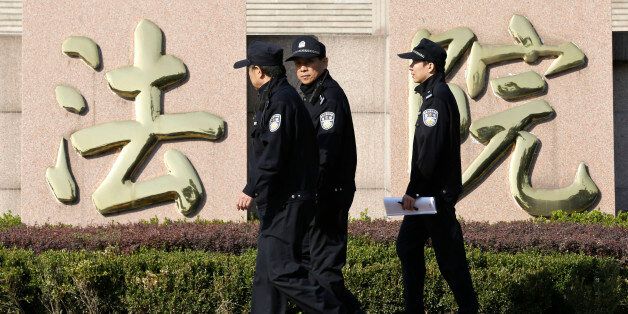 Policemen walk past Chinese characters reading