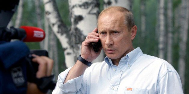 Prime Minister Vladimir Putin speaks on a cell phone with President Dmitry Medvedev, during a visit to a temporary shelter for the people whose houses were burned to the ground in the villages, surrounding Nizhny Novgorod, Russia's fifth-largest city, 475 km (300 miles) east of Moscow, Friday, July 30, 2010. The fires have spread quickly across more than 200,000 acres (90,000 hectares) in recent days after a record heat wave and severe drought that has plagued Russia for weeks.(AP Photo/RIA Novo