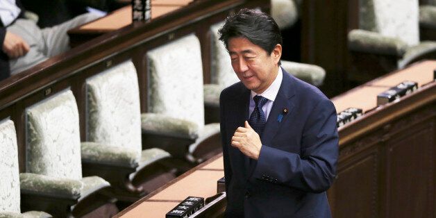 Japanese Prime Minister Shinzo Abe smiles during a vote of opposition-submitted no-confidence motion against his cabinet at the lower house of the parliament in Tokyo, Friday, Sept. 18, 2015. Opposition parties, in a last-ditch show of resistance, were delaying a vote on security bills by introducing a series of no-confidence measures against government ministers and parliamentary leaders on Friday. Japan's parliament is moving toward final approval of legislation that would loosen post-World Wa