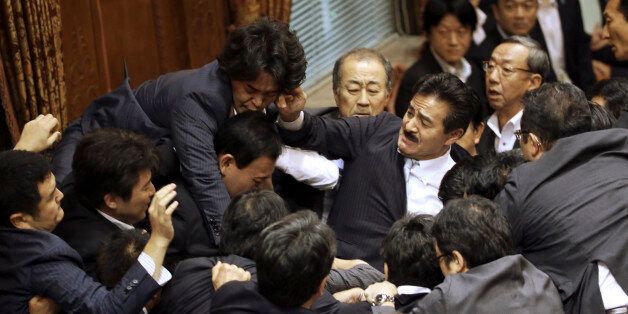 Opposition lawmakers surge toward the chairmanâs seat to protest as ruling party colleagues rush in to try to protect him during a committee voting of security bills at the upper house in Tokyo, Thursday, Sept. 17, 2015. Japanâs ruling Liberal Democratic Party pushed contentious security bills through a legislative committee, catching the opposition by surprise and causing chaos in the chamber. If the vote stands, the legislation will go to the upper house of parliament for final appro