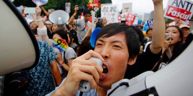Protesters shout slogans during a rally in front of the National Diet building in Tokyo, Sunday, Aug. 30, 2015. Thousands of Japanese protested outside the parliament a set of security bills designed to expand the role the country's military. The bills - a cornerstone of Prime Minister's Shinzo Abe's move to shore up Japan's defenses in the face of growing threats in the region - are expected to pass next month despite criticism they undermine Japanâs post-war pacifism. (AP Photo/Shizuo Kam