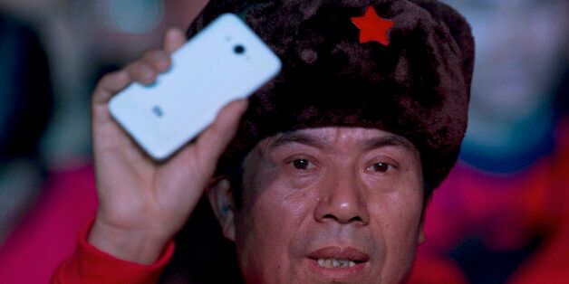 A fan of Xiaomi smartphone holds up one of the phones during a product unveiling event of the Chinese company in Beijing, Thursday, Jan. 15, 2015. The Chinese manufacturer on Thursday unveiled a new model that Lei said has processor size and performance comparable to Appleâs iPhone 6 but is thinner and lighter. (AP Photo/Ng Han Guan)