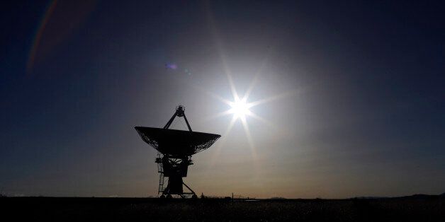 The sun sets behind an antenna at the National Radio Astronomy Observatory's Very Large Array, Tuesday, March 3, 2015, in Socorro County, N.M. (AP Photo/Patrick Semansky)