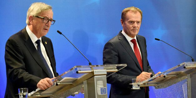 European Commission President Jean-Claude Juncker, left, and European Council President Donald Tusk, right, listen to the media after the emergency EU heads of state summit on the migrant crisis at the EU council building in Brussels on early Thursday, Sept. 24, 2015. European Union leaders, faced with a staggering migration crisis and deep divisions over how to tackle it, managed to agree early Thursday to send 1 billion euros ($1.1 billion) to international agencies helping refugees at camps n
