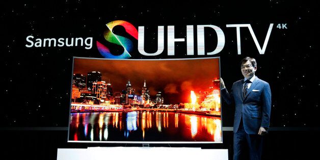 Kim Hyun-seok, head of Samsung Electronics' TV business, poses with its SUHD 4K TV during a press conference in Seoul, South Korea, Thursday, Feb. 5, 2015. South Korean electronics giant Samsung Electronics Co. has started domestic sales of high-end televisions powered by its Tizen operating system and plans to add washing machines, fridges and other appliances to the range of products that use the software.(Ahn Young-joon)