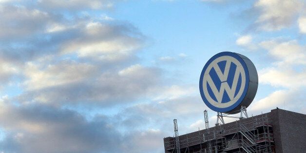 A giant logo of the German car manufacturer Volkswagen is pictured on top of a company's factory building in Wolfsburg, Germany, Saturday, Sept. 26, 2015. (AP Photo/Michael Sohn)