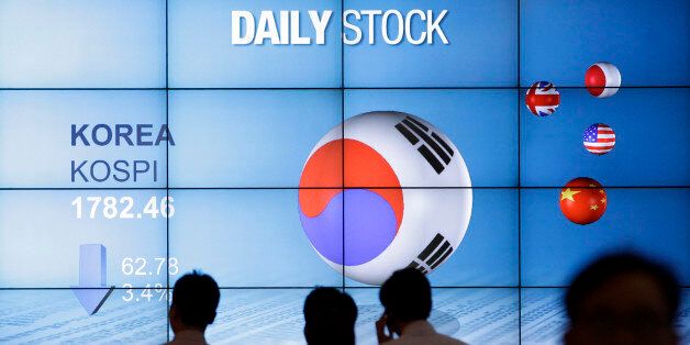 People walk past in front of the screen showing Korea Composite Stock Price Index (Kospi) in Seoul, South Korea, Friday, May 18, 2012. South Korea's Kospi lost 3.4 percent or 62.78 points at 1,782.46.  Asian stocks dived Friday after discouraging U.S. economic reports unnerved investors already worried about the stability of the 17-country euro currency union. (AP Photo/Lee Jin-man)
