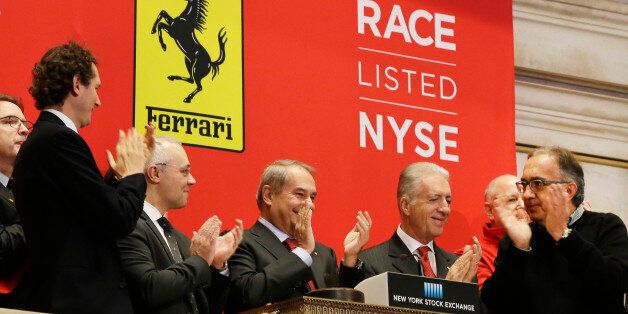 Fiat Chrysler chairman John Elkann, left, Ferrari CEO Amedeo Felisa, center, Piero Ferrari, son of Ferrari founder Enzo Ferrari, second right, and Fiat Chrysler CEO Sergio Marchionne, applaud at the opening bell at the New York Stock Exchange in honor of Ferrari's IPO, Wednesday, Oct. 21, 2015. The parent company, mass-market carmaker Fiat Chrysler Automobiles, is selling shares under the stock name RACE. (AP Photo/Richard Drew)