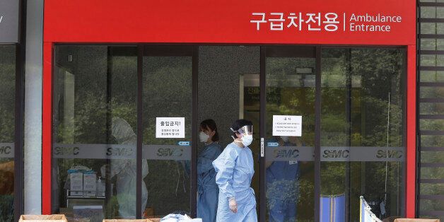 A hospital worker wears a mask as a precaution against the MERS, Middle East Respiratory Syndrome, virus as she comes out from an emergency room of Samsung Medical Center in Seoul, South Korea, Sunday, June 7, 2015. A fifth person in South Korea has died of the MERS virus, as the government announced Sunday it was strengthening measures to stem the spread of the disease and public fear.(AP Photo/Ahn Young-joon)