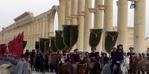 FILE - In this Sept. 27, 2002, file photo, a symbolic trade caravan representing the prosperous trade during the era of Queen Zanobya 260-273AD attend a show held in the ancient city of Palmyra, some 240 kilometers (150 miles) northeast of Damascus, Syria. Islamic State militants beheaded 81-year-old Khaled al-Asaad, a leading Syrian antiquities scholar who spent most of his life looking after the ancient ruins of Palmyra, then hung his body from a pole in a main square of the historic town, Syr