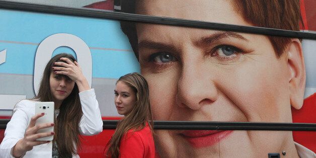Supporters of the conservative opposition Law and Justice party that is considered a favorite in Sunday general elections take  a selfie in front of the campaign bus of Beata Szydlo, the  partyâs candidate for prime minister, after a party convention that wrapped up months of campaigning in Warsaw, Poland, on Thursday, Oct. 22, 2015.(AP Photo/Czarek Sokolowski)