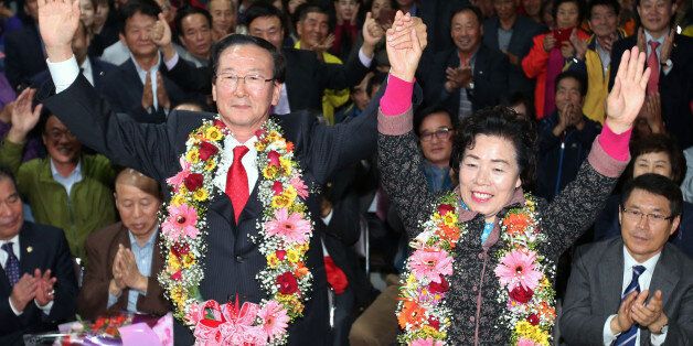 28일 열린 재보선 선거에서 경남 고성 군수로 당선된 새누리당 최평호 후보가 선거사무실에서 부인 이화순씨와 환호하고 있다.