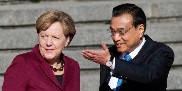 Chinese Premier Li Keqiang, right, shows the way for German Chancellor Angela Merkel during a welcome ceremony held outside the Great Hall of the People in Beijing, China, Thursday, Oct. 29, 2015. (AP Photo/Ng Han Guan)