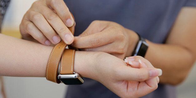 Letty Liang, of San Francisco, tries on the new Apple Watch Hermes at the Apple store Monday, Oct. 5, 2015, in Stanford, Calif. The watch, which starts at $1100, went on sale Monday. (AP Photo/Eric Risberg)