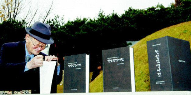 지난 2009년 11월 8일 서울 용산구 효창동 백범 김구 묘소에서 열린 ‘친일인명사전 발간 국민보고대회’에서 한 시민이 백범의 제단에 바쳐진 사전을 살펴보고 있다.