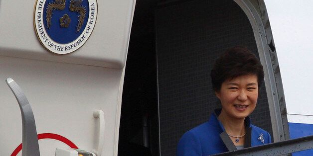 South Korean President Park Geun-hye smiles from her plane upon arrival at Bali airport, Indonesia, Sunday, Oct. 6, 2013 to attend the Asia-Pacific Economic Cooperation (APEC) forum. (AP Photo/Firdia Lisnawati)