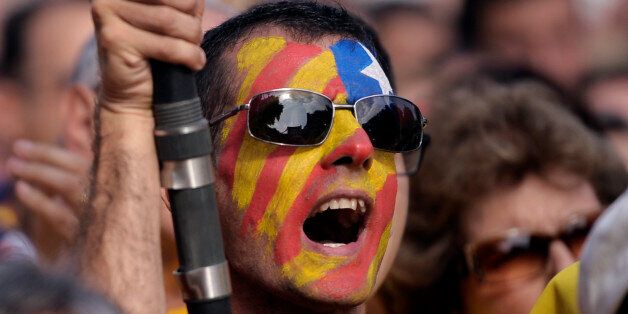 A supporter of the independence of the Catalonia region of Spain, with an estelada or pro independence flag painted on his face gathers in Catalonia square during a rally in Barcelona, Spain, Sunday, Oct. 19, 2014. Thousands of demonstrators crowded a central square in Barcelona during the main campaign event organized by two major pro independence civil society organizations ahead of the vote scheduled for Nov. 9th. Spain's wealthy Catalonia region calls off an independence vote but says an uno