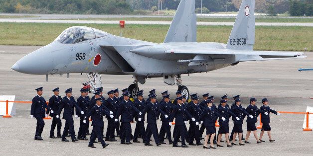 Japan Self-Defense Force (SDF) members walk in front of F-15 J/DJ Fighter during the annual Self-Defense Forces Commencement of Air Review at Hyakuri Air Base, north of Tokyo,  Sunday, Oct. 16, 2011. (AP Photo/Shizuo Kambayashi)