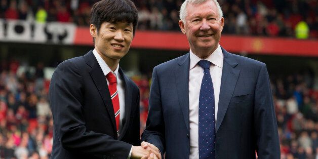 Manchester United former player Park Ji-sung, left, shakes hands with former manager Alex Ferguson as Park is introduced as a new ambassador for the club before the team's English Premier League soccer match against  Everton at Old Trafford Stadium, Manchester, England, Sunday Oct. 5, 2014. (AP Photo/Jon Super)