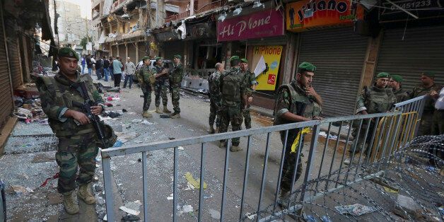 Lebanese army soldiers stand guard at the scene of Thursday's twin suicide bombings in Burj al-Barajneh, southern Beirut, Lebanon, Friday, Nov. 13, 2015. Schools and universities across Lebanon were shuttered Friday as the country mourned victims of twin suicide bombings that struck a crowded neighborhood south of the capital. (AP Photo/Bilal Hussein)