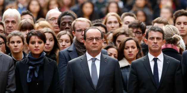 French President Francois Hollande, center, flanked by French Prime Minister Manuel Valls, right, and French Education Minister Najat Vallaud-Belkacem, center left, stands among students during a minute of silence in the courtyard of the Sorbonne University in Paris, Monday, Nov. 16 2015. A minute of silence was observed throughout the country in memory of the victims of last Friday's attack. (Guillaume Horcajuelo, Pool via AP)