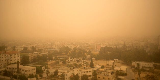 A sandstorm shrouds the Gaza strip, Tuesday, Sept. 8, 2015. An unseasonal sandstorm hit many countries in the Middle East with a blanket of yellow dust on Tuesday, sending hundreds of people to hospitals with breathing difficulties and causing the deaths of two women, officials said. (AP Photo/ Khalil Hamra)