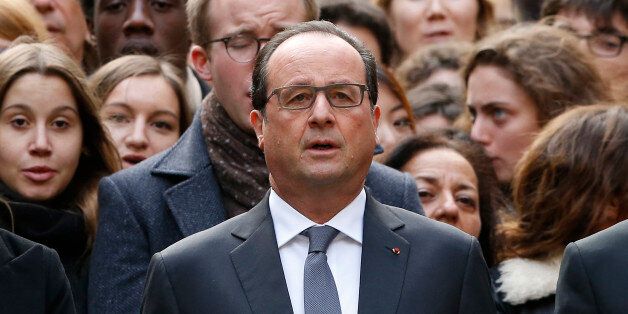 French President Francois Hollande stands among students during a minute of silence in the courtyard of the Sorbonne University in Paris, Monday, Nov. 16 2015. A minute of silence was observed throughout the country in memory of the victims of last Friday's attack. (Guillaume Horcajuelo, Pool via AP)
