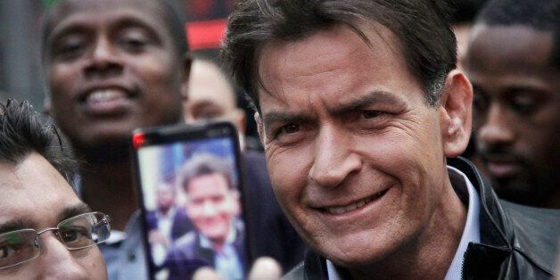 FILE - In this Monday, Jan. 14, 2013, file photo, actor Charlie Sheen is mobbed for autographs and photos as he makes his way through Times Square in New York. In an interview Tuesday, Nov. 17, 2015, on NBC's