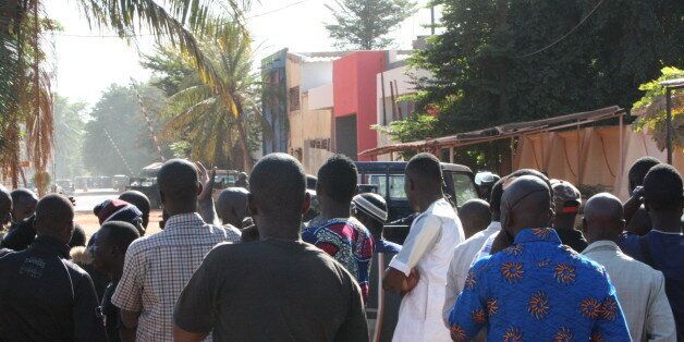 Onlookers gather near the Radisson Blu hotel after gunmen stormed the building in Bamako, Mali, Friday, Nov. 20, 2015. Men shouting