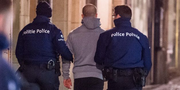 Police lead away a man during a raid in Brussels on Sunday, Nov. 22, 2015. Western leaders stepped up the rhetoric against the Islamic State group on Sunday as residents of the Belgian capital awoke to largely empty streets and the city entered its second day under the highest threat level. With a menace of Paris-style attacks against Brussels and a missing suspect in the deadly Nov. 13 attacks in France last spotted crossing into Belgium, the city kept subways and underground trams closed for a