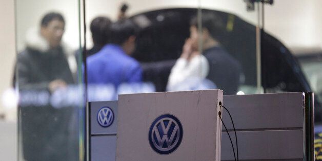 Customers look at a Volkswagen's vehicle at a dealership in Seoul, South Korea,Thursday, Nov. 26, 2015. South Korea said Thursday it fined Volkswagen $12.3 million and ordered recalls of 125,522 diesel vehicles after the government found their emissions tests were rigged. (AP Photo/Ahn Young-joon)