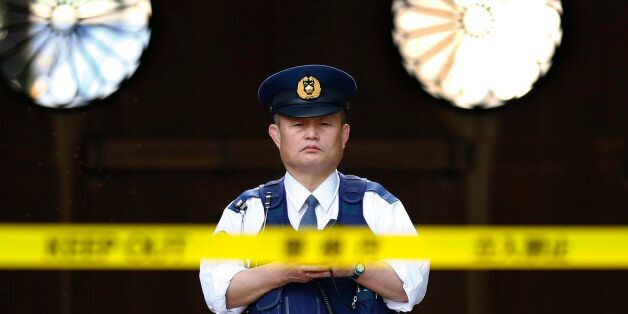In this Tuesday, Nov. 24, 2015, file photo, a police officer stands guard in front of the south gate of Yasukuni shrine in Tokyo. An explosion on Monday damaged a public restroom at a controversial shrine in Tokyo that honors Japanese war dead, with police suspecting foul play. No one was injured. (AP Photo/Shizuo Kambayashi, File)