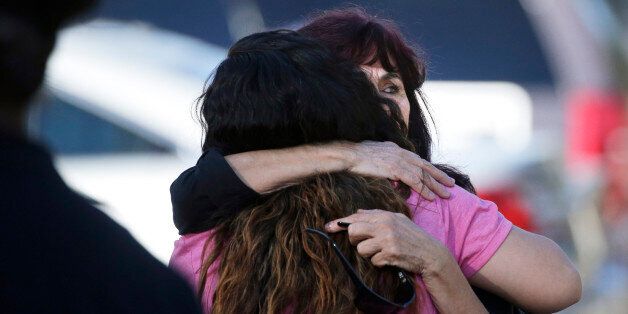 Teresa Hernandez, facing camera, is comforted by a woman as she arrives at a social services center in San Bernardino, Calif., where one or more gunmen opened fire, shooting multiple people on Wednesday, Dec. 2, 2015. (AP Photo/Jae C. Hong)