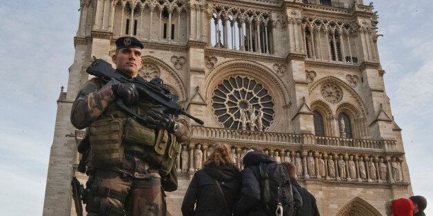 A soldier patrols at the Notre Dame cathedral in Paris, Wednesday, Dec. 30, 2015. France's defense minister has visited troops on duty ahead of unusually tense New Year's Eve celebrations in Paris after November attacks that left 130 dead and hundreds injured. (AP Photo/Michel Euler)