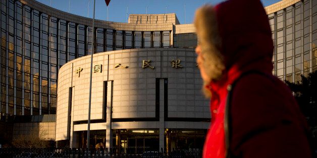 In this Friday, Jan. 8, 2016 photo, a woman walks past China's central bank, the People's Bank of China, in Beijing. Stock market and currency turmoil has battered Chinese leadersâ reputation as shrewd economic managers and fed doubts about their ability and willingness to push more wrenching reforms. (AP Photo/Mark Schiefelbein)