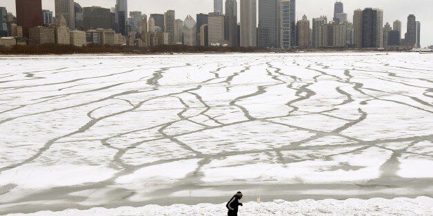 A lone jogger runs in the snow near the Adler Planetarium    and Monroe Harbor on Lake Michigan Friday, Jan. 22, 2016, in Chicago. The Chicago area will dodge a major snowstorm where one in seven Americans will get at least half a foot of snow outside their homes when this weekend's big storm has finished delivering blizzards, gale-force winds, white-out conditions and flooding to much of the eastern United States. (AP Photo/Charles Rex Arbogast)