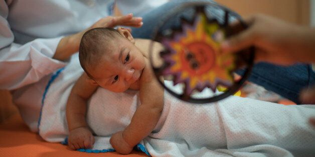 Three-month-old Daniel, who was born with microcephaly, undergoes physical therapy at the Altino Ventura foundation in Recife, Brazil, Thursday, Jan. 28, 2016. Brazilian officials still say they believe there's a sharp increase in cases of microcephaly and strongly suspect the Zika virus, which first appeared in the country last year, is to blame. The concern is strong enough that the U.S. Centers for Disease Control and Prevention this month warned pregnant women to reconsider visits to areas w