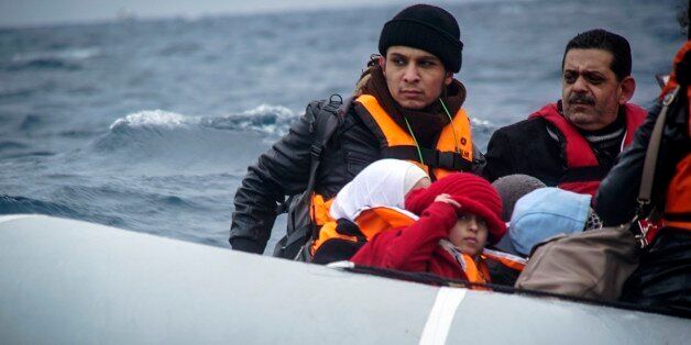 Refugees and migrants on a dinghy arrive from the Turkish coast to the northeastern Greek island of Lesbos, on Friday, Jan. 29, 2016. A migration monitoring agency says deaths of refugees and migrants crossing the Aegean Sea between Turkey and Greece are
