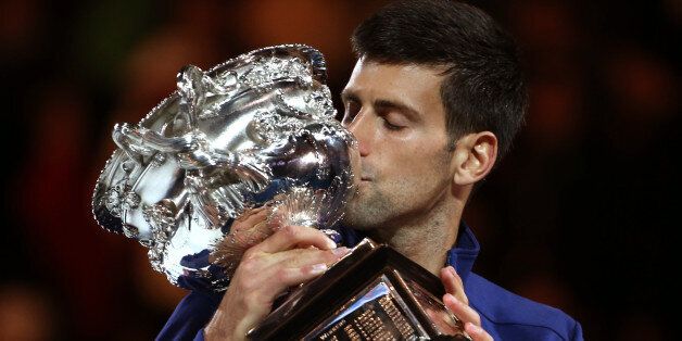 Novak Djokovic of Serbia kisses his trophy after defeating Andy Murray of Britain in the men's singles final at the Australian Open tennis championships in Melbourne, Australia, Sunday, Jan. 31, 2016.(AP Photo/Rick Rycroft)