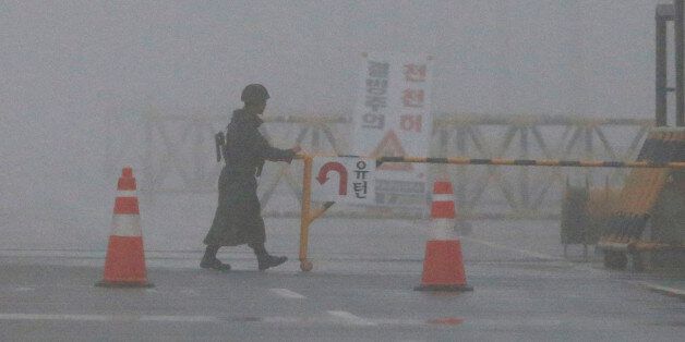 A South Korean Army soldier adjusts barricade on a foggy and rainy morning at Unification Bridge near the border village of Panmunjom in Paju, South Korea, Friday, Feb. 12, 2016. North Korea on Thursday ordered a military takeover of a factory park that had been the last major symbol of cooperation with South Korea, calling Seoul's earlier suspension of operations at the jointly run facility as punishment for the North's recent rocket launch a
