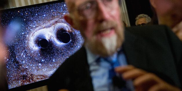 A visual of gravitational waves from two converging black holes is depicted on a monitor behind Laser Interferometer Gravitational-Wave Observatory (LIGO) Co-Founder Kip Thorne as he speaks to members of the media following a news conference at the National Press Club in Washington, Thursday, Feb. 11, 2016, as it is announced that scientists they have finally detected gravitational waves, the ripples in the fabric of space-time that Einstein predicted a century ago. The announcement has electrif