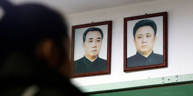 A visitor tours near the pictures of North Korean founder late Kim Il Sung, left, and his son, leader late Kim Jong Il at the exhibition hall of the unification observatory in Paju, South Korea, Wednesday, Feb. 10, 2016. South Korea says it will suspend the operations at a joint industrial park with North Korea in response to the North's recent rocket launch.(AP Photo/Lee Jin-man)