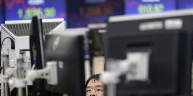 A currency trader watches monitors at the foreign exchange dealing room of the KEB Hana Bank headquarters in Seoul, South Korea, Friday, Feb. 12, 2016. Japanâs main stock index dived Friday, leading other Asian markets lower, after a sell-off in banking shares roiled investors in the U.S. and Europe. (AP Photo/Ahn Young-joon)