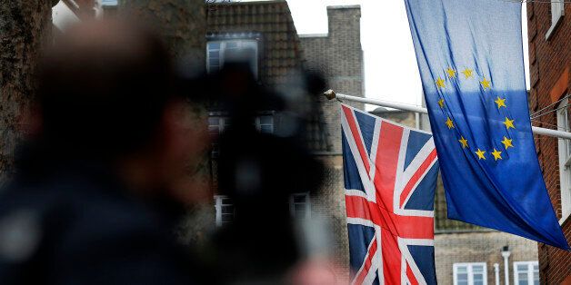 A camera man films the EU flag beside the Union flag at Europa House in London, Wednesday, Feb. 17, 2016. Britain's Prime Minister, David Cameron, will attend an EU summit in Brussels starting Thursday. (AP Photo/Frank Augstein)