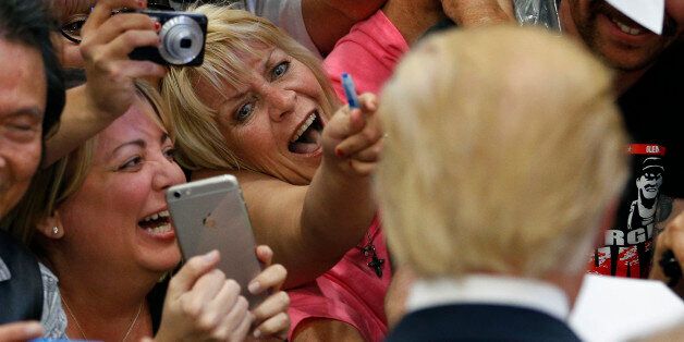 People react while meeting Republican presidential candidate Donald Trump at a campaign rally Monday, Feb. 22, 2016, in Las Vegas. (AP Photo/John Locher)
