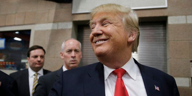 Republican presidential candidate Donald Trump smiles as he greets voters at a caucus site Tuesday, Feb. 23, 2016, in Las Vegas. (AP Photo/Jae C. Hong)