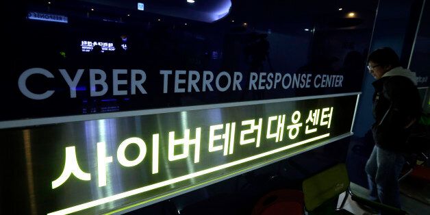 A man walks past next to a sign of Cyber Terror Response Center at National Police Agency in Seoul, South Korea, Thursday, March 21, 2013. A Chinese Internet address was the source of a cyberattack on one company hit in a massive network shutdown that affected 32,000 computers at six banks and media companies in South Korea, initial findings indicated Thursday. (AP Photo/Lee Jin-man)