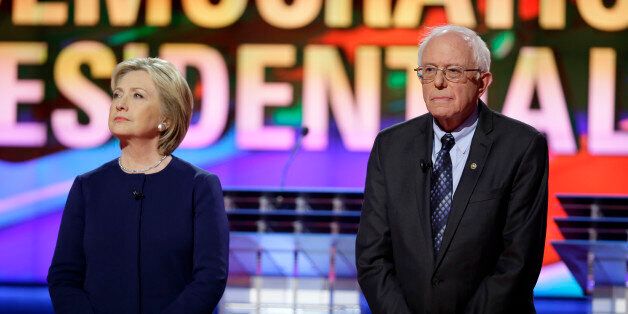 Democratic presidential candidates Hillary Clinton, left, and Sen. Bernie Sanders, I-Vt., stand on stage before a Democratic presidential primary debate at the University of Michigan-Flint, Sunday, March 6, 2016, in Flint, Mich. (AP Photo/Charlie Neibergall)